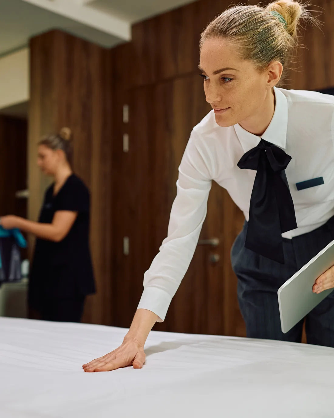 Hotel Managerin ist zufrieden mit dem hergerichteten Hotelbett